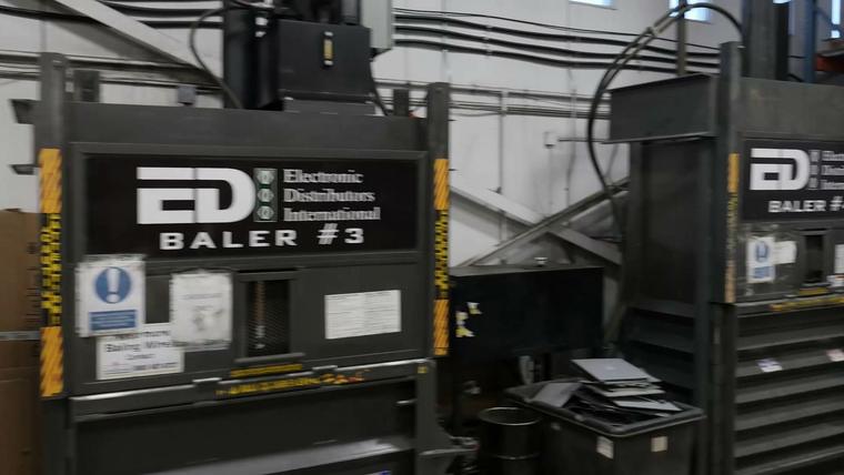 Balers on the plant floor, lettered with the EDI name