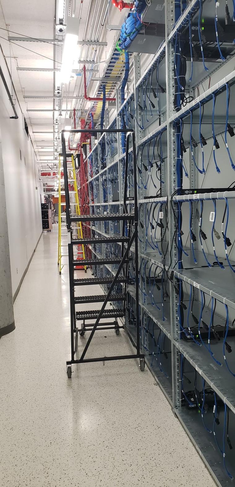 Tall steel shelving built along a wall, with wiring