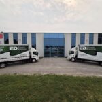 Two wrapped EDI Inc box trucks parked outside the company's Orillia facility at 15 Progress Drive